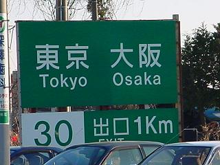 「東京　大阪　出口　1キロ」と書かれた看板